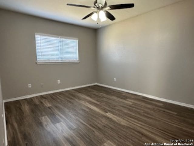 spare room featuring dark hardwood / wood-style flooring and ceiling fan