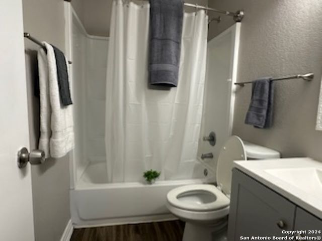 full bathroom featuring shower / tub combo, hardwood / wood-style floors, vanity, and toilet