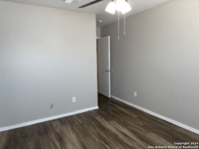 unfurnished room with ceiling fan and dark wood-type flooring