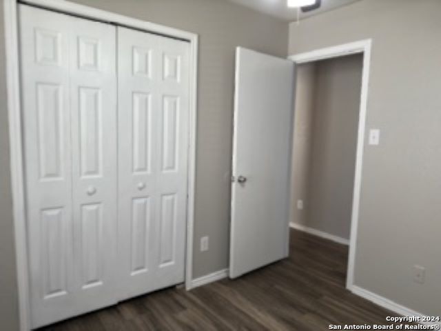 unfurnished bedroom featuring a closet and dark hardwood / wood-style flooring