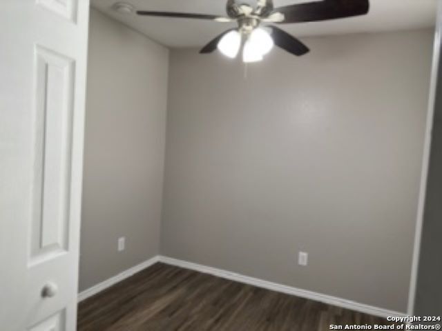 unfurnished room featuring dark hardwood / wood-style floors and ceiling fan