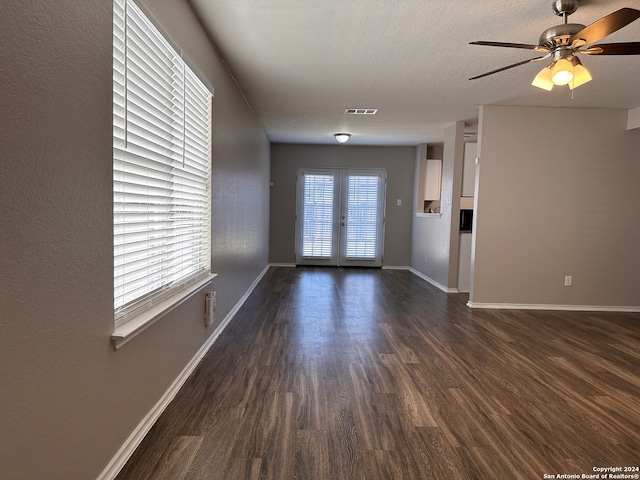 interior space featuring ceiling fan, dark wood-type flooring, french doors, and a textured ceiling