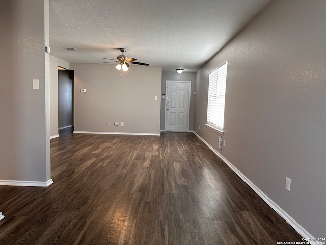 interior space with dark wood-type flooring, a textured ceiling, and ceiling fan