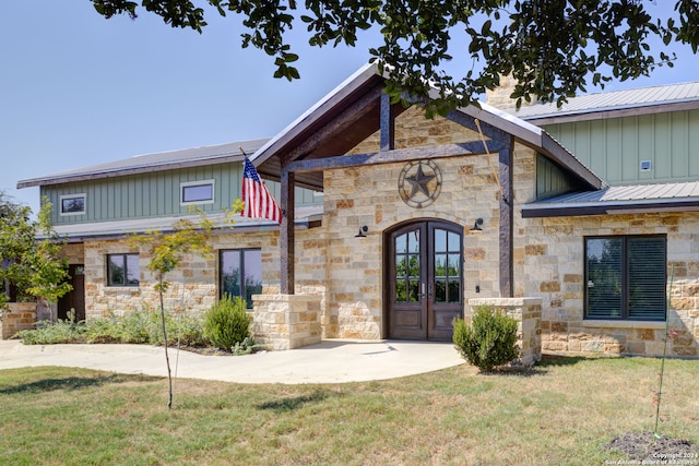 view of front facade featuring french doors and a front lawn