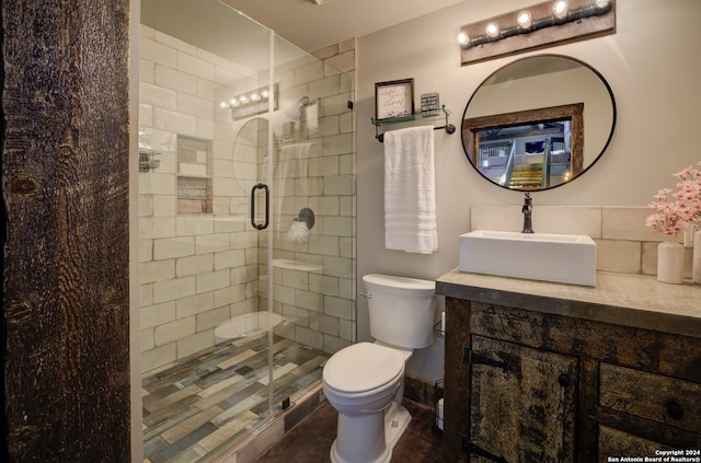 bathroom featuring vanity, toilet, and a shower with shower door