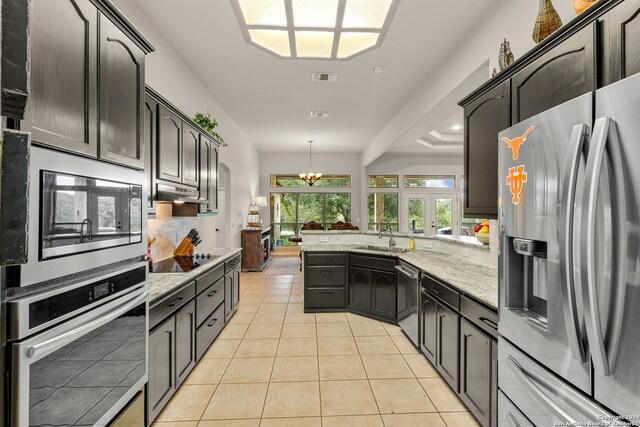 kitchen with a chandelier, sink, hanging light fixtures, appliances with stainless steel finishes, and light tile patterned floors