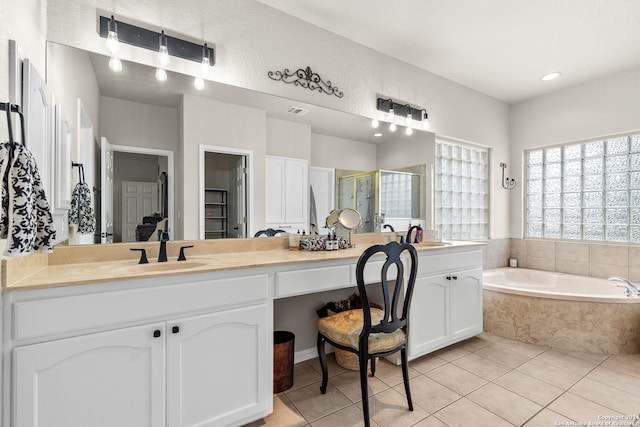 bathroom featuring tile patterned flooring, vanity, and shower with separate bathtub