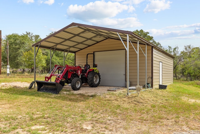 view of outdoor structure featuring a yard, a carport, and a garage