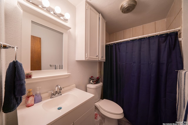 bathroom with curtained shower, vanity, a textured ceiling, and toilet