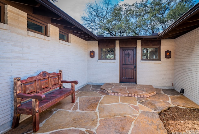 view of exterior entry with a patio