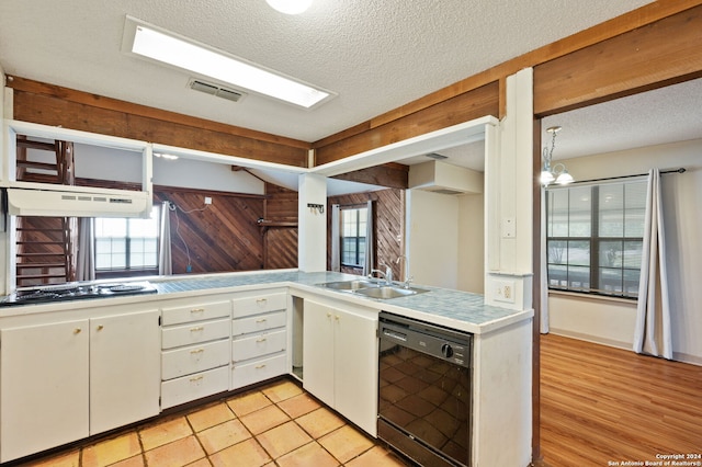 kitchen with light wood-type flooring, black appliances, ventilation hood, sink, and white cabinetry