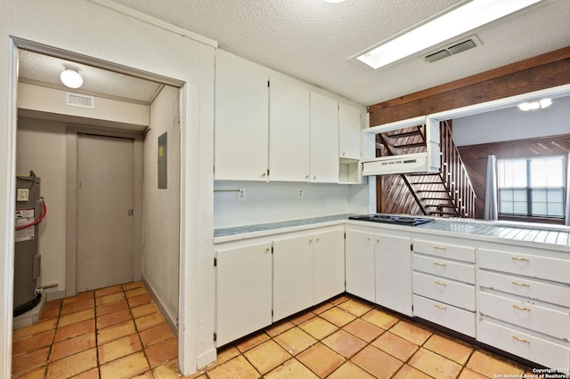 kitchen with custom exhaust hood, a textured ceiling, white cabinetry, water heater, and gas stovetop