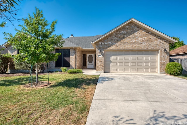 single story home featuring a front lawn, driveway, brick siding, and a garage
