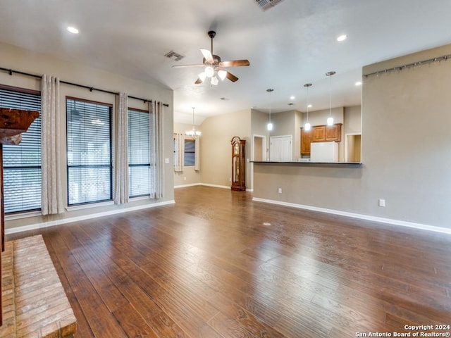 unfurnished living room featuring baseboards, dark wood-type flooring, visible vents, and ceiling fan with notable chandelier
