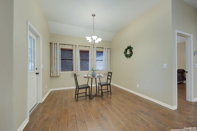 dining area featuring dark hardwood / wood-style flooring, a chandelier, and vaulted ceiling