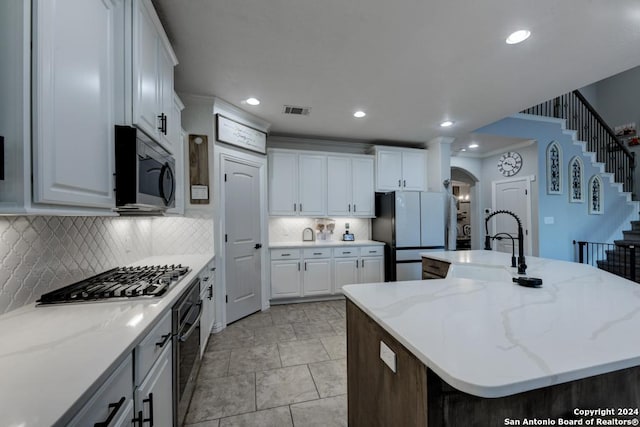 4815 Isaac Ryan, San Antonio, TX 78253 - kitchen with visible vents, decorative backsplash, an island with sink, white cabinetry, and stainless steel appliances