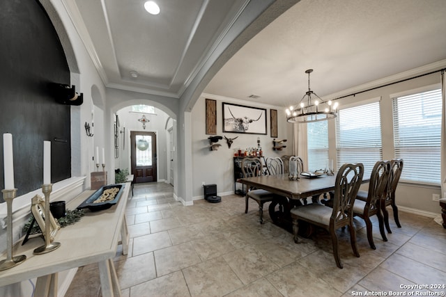 tiled dining area with ornamental molding, a notable chandelier, and plenty of natural light