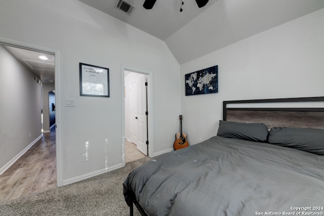 bedroom with vaulted ceiling, light hardwood / wood-style floors, and ceiling fan