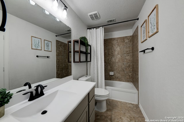 full bathroom featuring tile patterned floors, shower / bath combo, toilet, vanity, and a textured ceiling