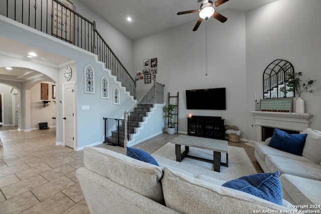 tiled living room featuring ceiling fan and a high ceiling