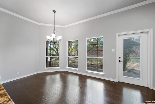 unfurnished dining area featuring dark wood-type flooring, ornamental molding, and a notable chandelier