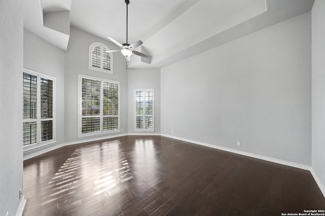 spare room with ceiling fan, dark wood-type flooring, and a high ceiling