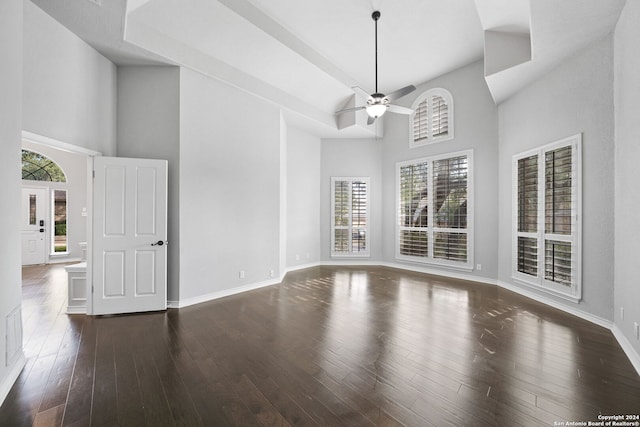 interior space featuring ceiling fan, dark wood-type flooring, and a high ceiling