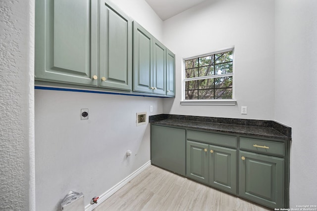 laundry area with gas dryer hookup, cabinets, hookup for a washing machine, light wood-type flooring, and electric dryer hookup