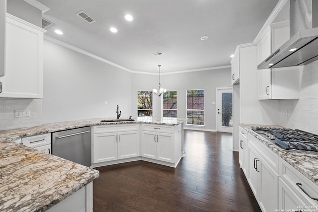 kitchen with wall chimney range hood, dark wood-type flooring, backsplash, appliances with stainless steel finishes, and white cabinetry