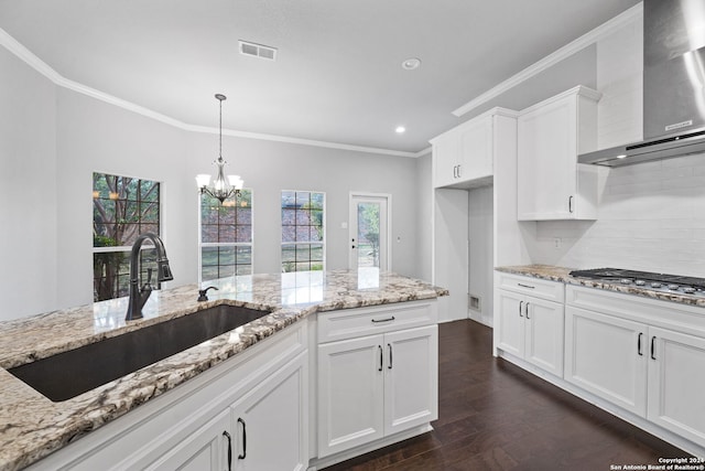 kitchen with wall chimney exhaust hood, stainless steel gas cooktop, white cabinetry, and dark hardwood / wood-style flooring