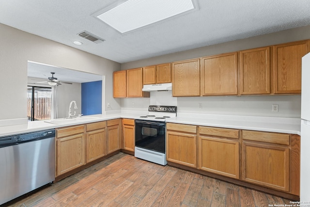 kitchen featuring white electric range oven, light wood-type flooring, dishwasher, sink, and a textured ceiling