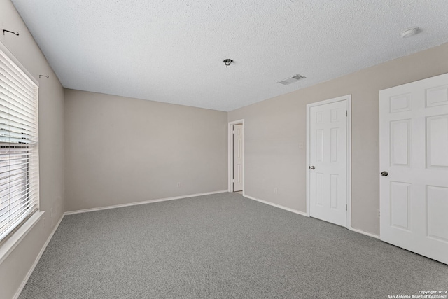 unfurnished bedroom with carpet floors and a textured ceiling