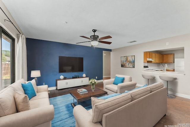 living room featuring ceiling fan and light hardwood / wood-style flooring