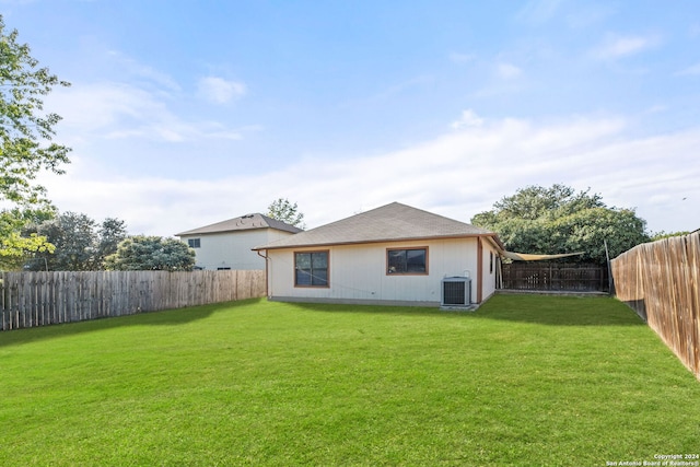 back of house with a yard and central AC