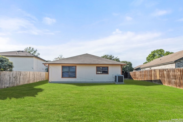 back of house featuring a lawn and central AC unit