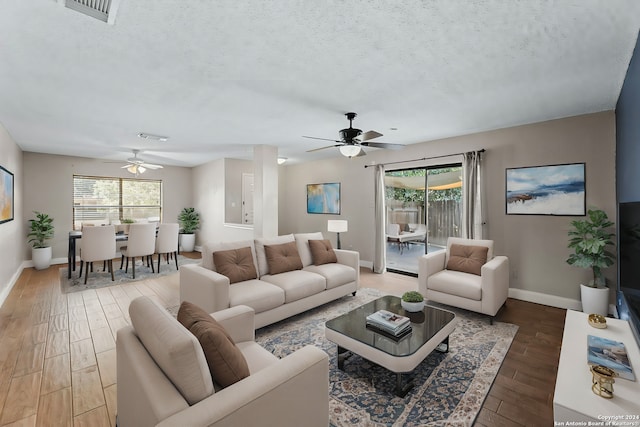 living room with hardwood / wood-style floors, a textured ceiling, and ceiling fan