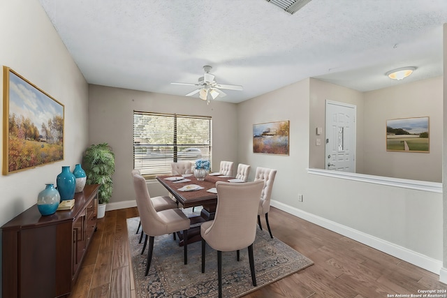 dining room featuring ceiling fan, a textured ceiling, and dark hardwood / wood-style flooring