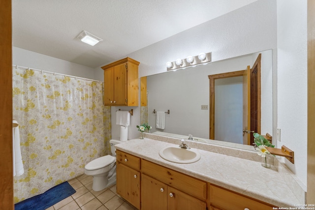 bathroom with tile patterned floors, toilet, vanity, and a textured ceiling