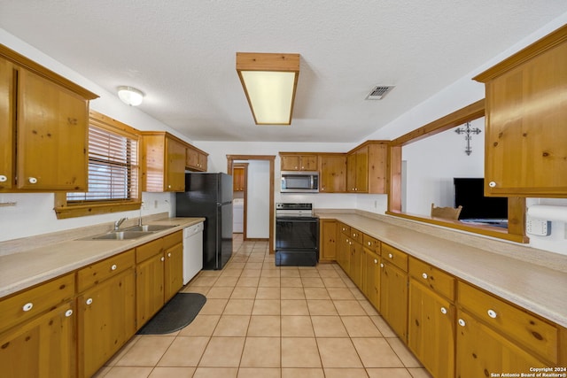 kitchen featuring light tile patterned flooring, black appliances, sink, and a textured ceiling