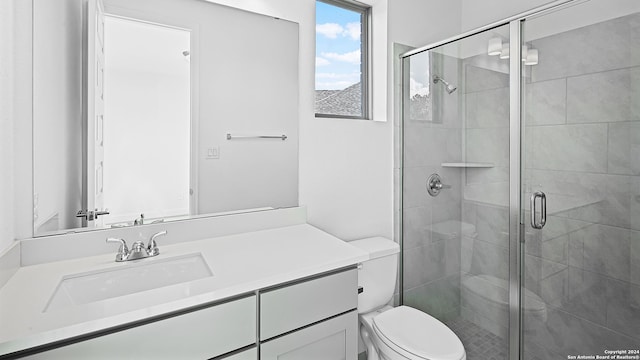 bathroom with toilet, walk in shower, and vanity