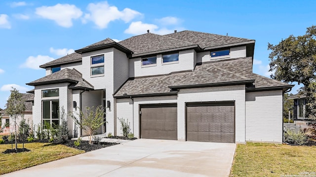 prairie-style house featuring a front lawn and a garage