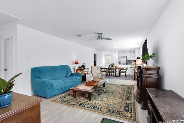 living room with ceiling fan and light wood-type flooring