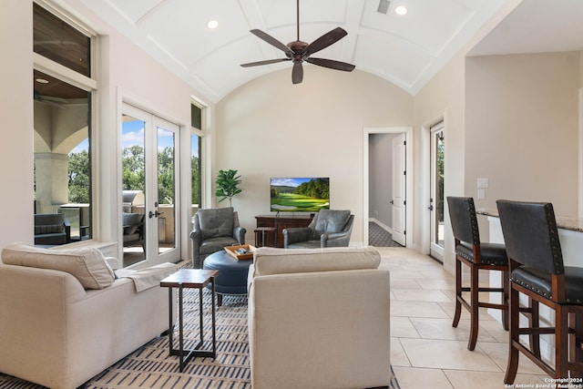 tiled living room featuring high vaulted ceiling, ceiling fan, and french doors