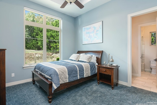 bedroom with ceiling fan, connected bathroom, and multiple windows