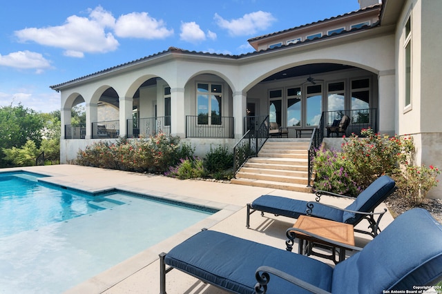 view of pool with french doors, a patio, and ceiling fan