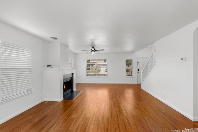 unfurnished living room featuring hardwood / wood-style floors and ceiling fan