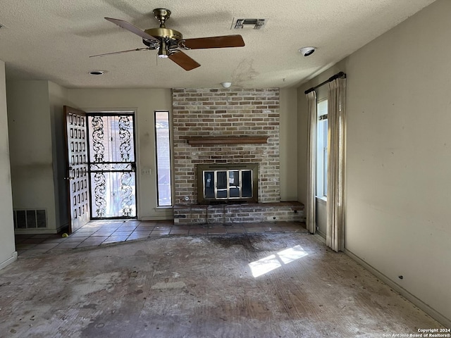 unfurnished living room with visible vents, baseboards, and a textured ceiling