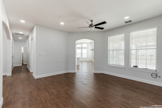 spare room with ceiling fan, dark wood-type flooring, and a wealth of natural light