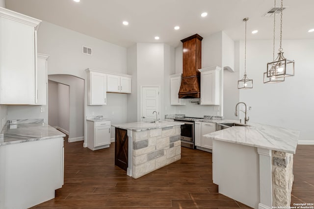 kitchen with kitchen peninsula, stainless steel range with electric stovetop, sink, and white cabinets