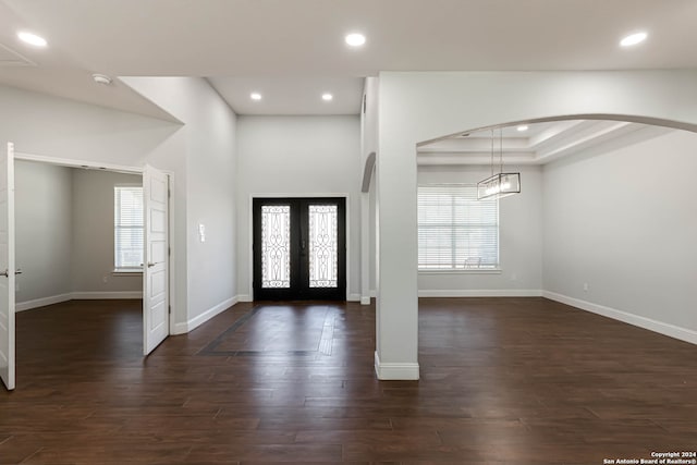 foyer entrance featuring french doors, dark hardwood / wood-style floors, and a tray ceiling